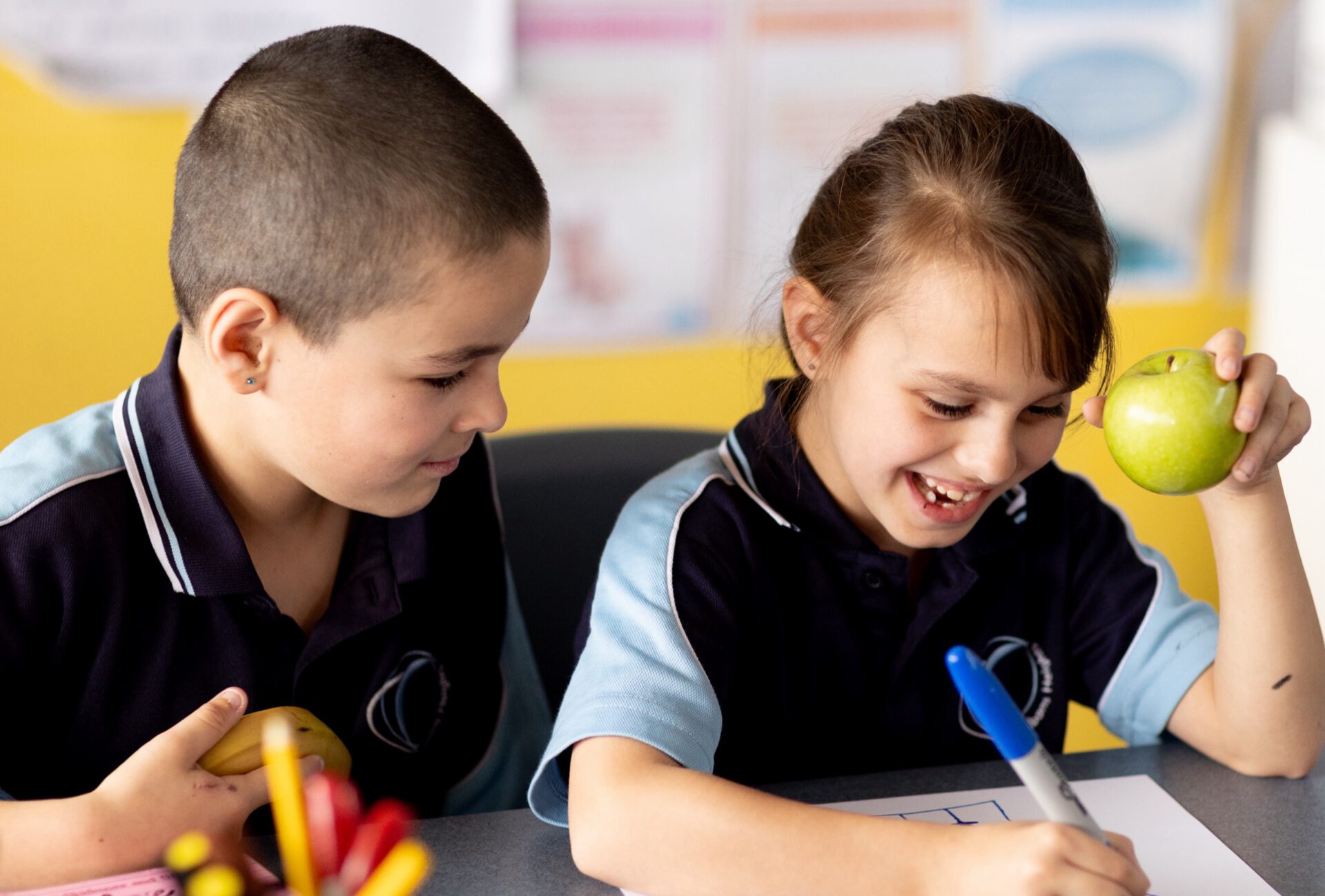 Students with fresh fruit in a classroom
