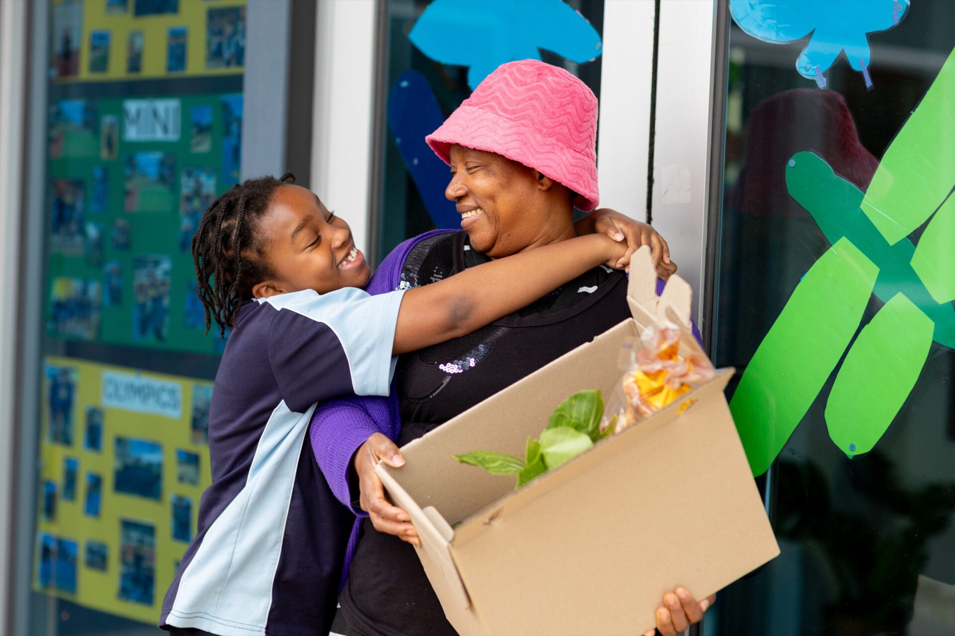 A volunteer handing a box of fresh food to a child