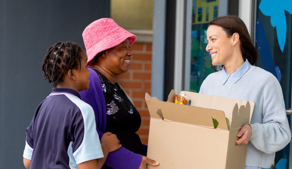 A family collecting their box from school staff